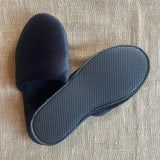 Black closed toe deluxe fleece slipper with 5mm textured EVA non-slip sole. 
