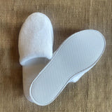 White closed toe deluxe fleece slipper with 5mm textured EVA non-slip sole. 