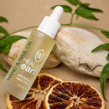 pinotage therapy nourishing hand and nail oil, 30ml, rested on rocks with dried fruit and leaves