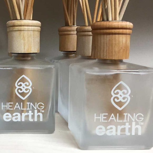 Healing earth glass bottle with rattan diffuser reeds and wooden cap available at SR Amenities Hotel and Spa Supplies.