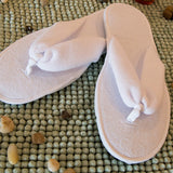 Washable and reusable thong style guest and spa slipper from terry towelling fabric with textured water resistant sole and closed in the colour white. Shop at www.sramenities.co.za